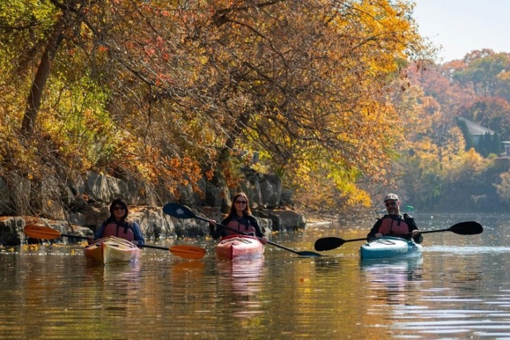 a group of people riding on the back of a boat in the water