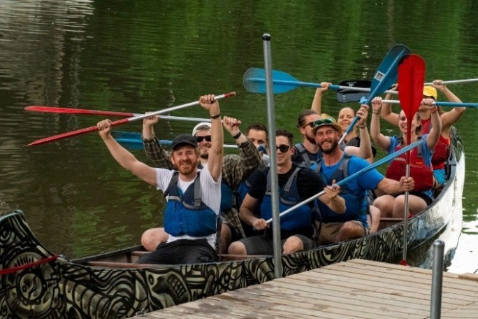 a group of people rowing a boat in a body of water